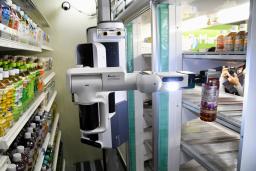 <p>　ペットボトルを店の倉庫（左）から取り出し、棚に並べるロボット＝２日午後、東京都千代田区</p>