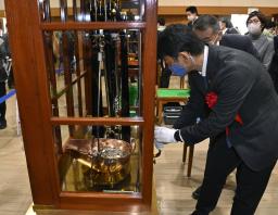 <p>　貨幣が規定を満たす重さで製造されているかをてんびんで調べる高村正大財務政務官＝１５日午前、大阪市の造幣局</p>