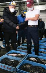 <p>　フグの初競りで「袋競り」をする競り人（右）と仲買人＝４日未明、山口県下関市の南風泊仮設市場</p>