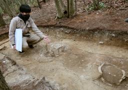 　富雄丸山古墳の２段目で見つかった二つのひれ付き円筒埴輪と、奈良市教委の村瀬陸主事＝３日午後、奈良市