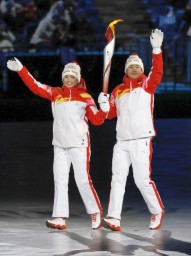 　北京冬季五輪の開会式で聖火台に向かう、最終走者のノルディックスキー複合男子の趙嘉文（右）と距離女子のジニゲル・イラムジャン＝４日、北京（共同）