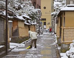 　金沢市の中心部、長町武家屋敷跡周辺で除雪をする人＝５日午前