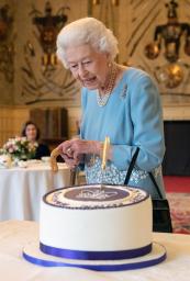 　５日、英東部サンドリンガムの別邸で開かれたレセプションでケーキをカットするエリザベス女王（ゲッティ＝共同）