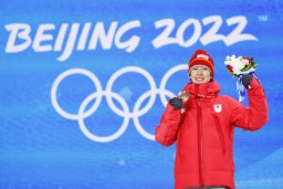 　フリースタイルスキー男子モーグルのメダルセレモニーで、銅メダルを手に笑顔の堀島行真＝６日、張家口（共同）