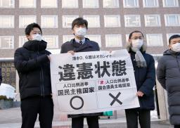　衆院選の「１票の格差」訴訟の判決を受け、札幌高裁前で「違憲状態」と書かれた紙を掲げる弁護士＝７日午後