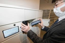　専用ロッカーの操作を実演する象印マホービンの担当者＝８日午後、神戸市役所