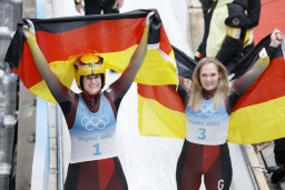 　女子１人乗りで五輪３連覇を達成し、国旗を掲げるドイツのナタリー・ガイゼンベルガー。右は２位のアナ・ベライター＝延慶（共同）