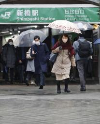 　ＪＲ新橋駅前を傘を差して歩く人たち。関東甲信を中心に大雪が降る恐れがある＝１０日午前