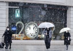 　雪が降る中、東京・銀座を歩く人たち＝１０日午後３時９分