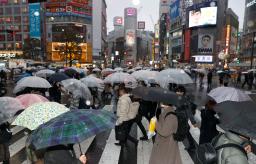 　雪が降る中、東京・渋谷のスクランブル交差点を歩く人たち＝１０日午後