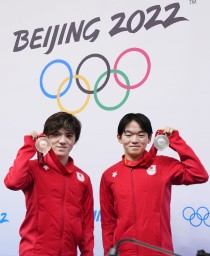 　一夜明けの記者会見でメダルを掲げる、フィギュアスケート男子で銀の鍵山優真（右）と銅の宇野昌磨＝１１日、北京（共同）