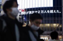 　国内で報告された新型コロナウイルス感染症による死者数が、累計で２万人を超えたことを伝える電光掲示板＝１１日午後、東京・渋谷
