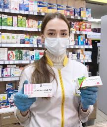 　ロシア・ウラジオストクの薬局で、トリメタジジンの箱を持つ店員＝１２日（共同）