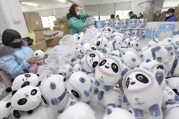 　北京冬季五輪の大会マスコット「ビンドゥンドゥン」グッズを箱詰めする作業員＝８日、中国江蘇省（新華社＝共同）