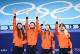 　スピードスケート・ショートトラック女子３０００メートルリレーで金メダルを獲得し、表彰台で天国の仲間へ投げキッスを送るオランダの選手たち＝１３日、北京（タス＝共同）