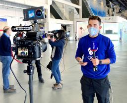 　裁定について中継で伝えるロシアのテレビ局のリポーター＝１４日、北京（共同）