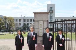 　大阪公立大の看板の前で記念写真に納まる辰巳砂昌弘学長（左から２人目）ら＝１日午前、大阪市住吉区