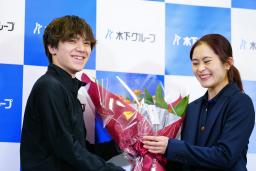 　引退会見で、宇野昌磨（左）から花束を受け取り、笑顔を見せるフィギュアスケート女子の宮原知子＝１日