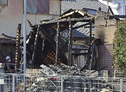 　住宅が全焼した現場を調べる捜査員ら＝２１年１０月、甲府市
