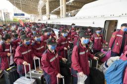 　中国・上海行きの列車に乗り込む医療関係者ら＝３日、中国江西省（新華社＝共同）