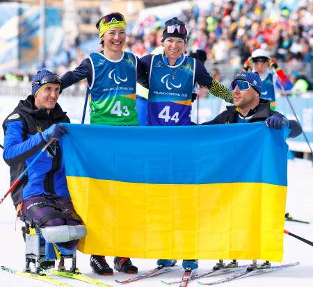 <p>　ノルディックスキー距離混合１０キロリレーで銀メダルを獲得し、国旗を掲げるオレクサンドラ・コノノワ（左から２人目）らウクライナ選手＝１４日、イタリア・テーゼロ（共同）</p>