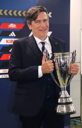 <p>　サッカー女子日本代表のアジア・カップ優勝報告の記者会見で、笑顔で優勝カップを持つニールセン監督＝２３日、東京都文京区</p>