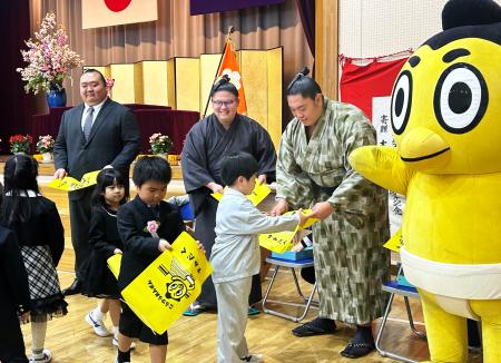 <p>　小梅小学校を訪問し、ランドセルカバーを配る桐山親方（左端）ら＝８日、東京都墨田区</p>