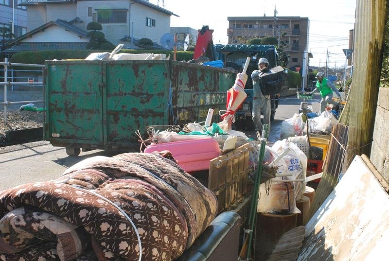 浸水で出た災害ごみを搬出する作業員＝４日午前９時ごろ、茂原市