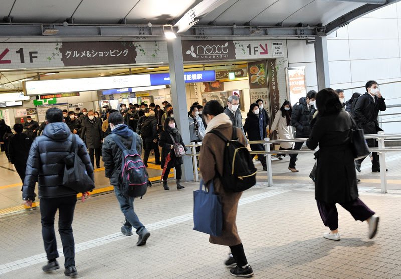 マスク姿で通勤する人たち＝１２日午前７時半ごろ、船橋市の京成船橋駅前
