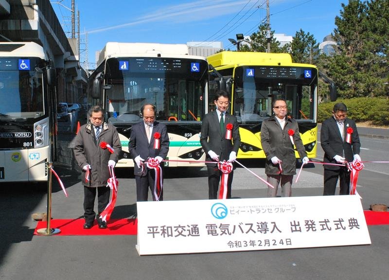平和交通が導入する電気バスの前でテープカットする式典出席者＝２４日、千葉市美浜区