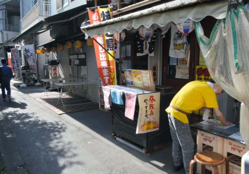 開店時間を前に店先を入念に消毒して準備する焼き鳥店＝２０日、船橋市内