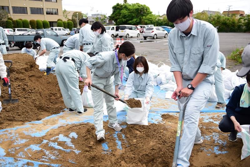土のうを作る職員＝１４日、多古町役場駐車場
