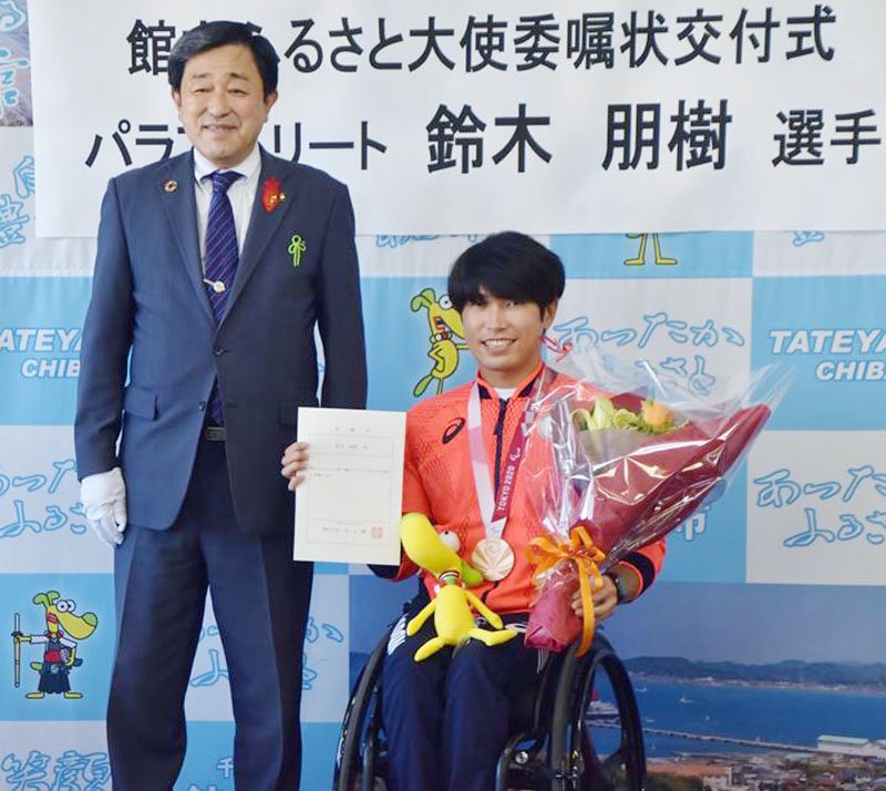 館山ふるさと大使の委嘱状を掲げる鈴木選手（右）と金丸市長＝６日、館山市役所