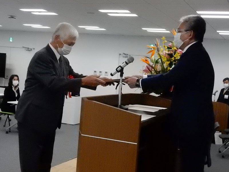 功績者（左）を表彰し記念の盾を贈る小出市長＝市原市役所