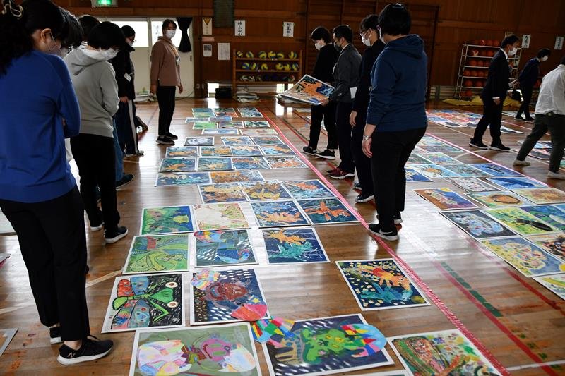 寄せられた作品を床に並べ審査する教員ら＝２５日、松戸市立和名ケ谷小学校