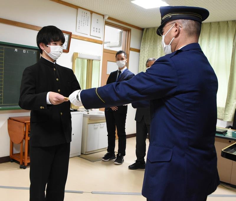 菅谷署長から感謝状を受け取る庄司さん（左）＝千葉市美浜区の市立高洲中学校
