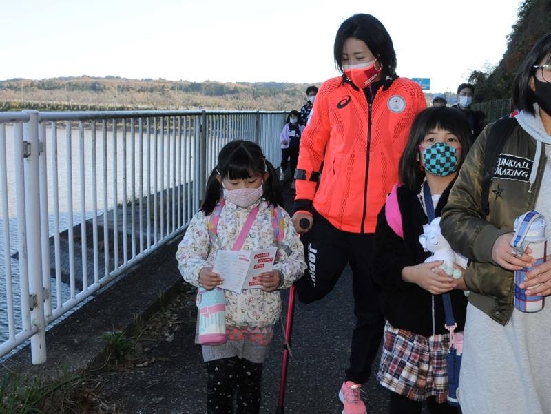 手術直後に市民ウオーキング大会に参加し交流する秦選手（中央）＝１１月２８日、市原市の高滝湖畔
