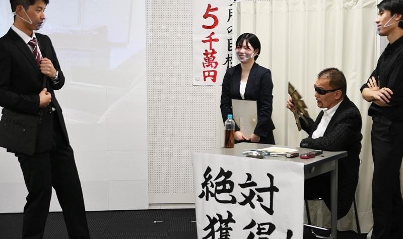 千葉県警から電話de詐欺の広報大使に委嘱された蝶野さん（右から２人目）は、寸劇の中で詐欺グループのボス役を演じた＝１０月２９日、県警本部
