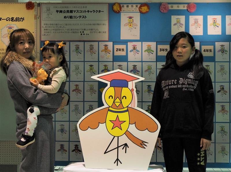 マスコットキャラクターの「おかピィ」を前に、母親に抱かれた妃香ちゃん（左）と佐藤さん＝袖ケ浦市平岡公民館
