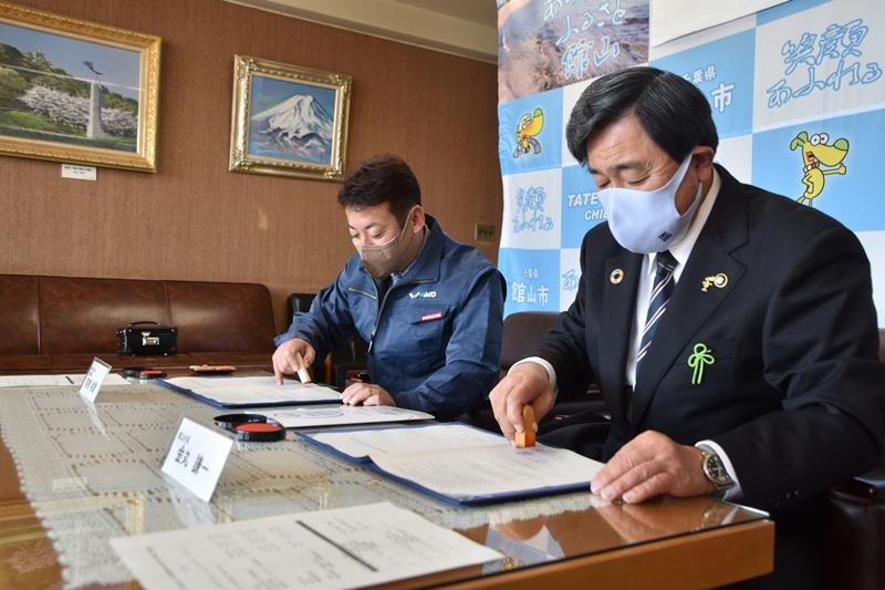 協定書に調印する金丸市長（右）と和幸の前橋社長＝館山市役所
