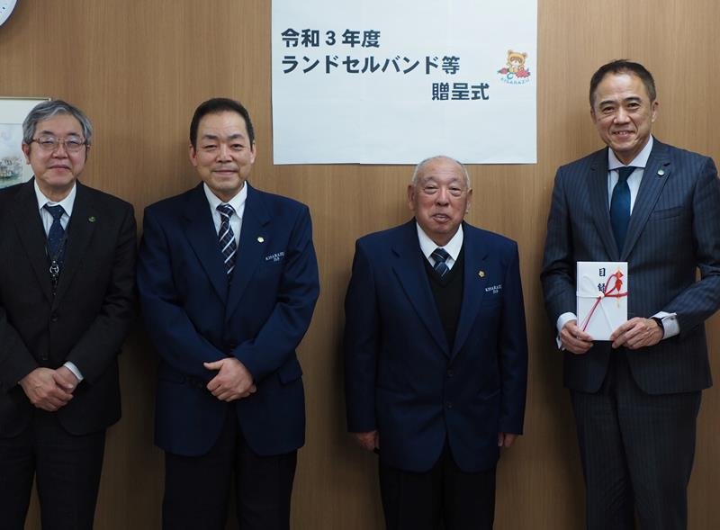 ランドセルバンドなどを贈った田丸代表理事（右から２人目）ら

