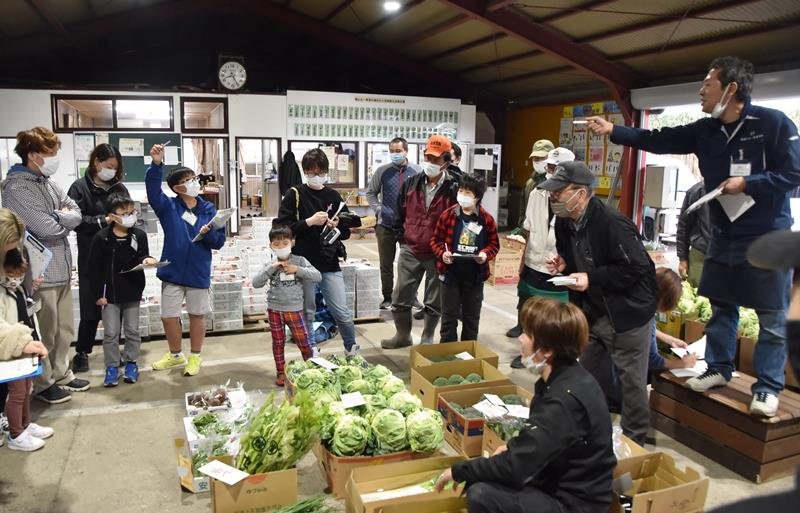地元で採れた新鮮な野菜に値段を付ける子どもたち＝２６日、館山市の館山丸一青果市場
