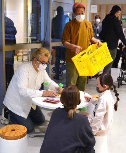 黄色いプラスチックかごのワークショップを開いた岩沢兄弟のひとしさん（左）とたかしさん＝２６日、千葉市中央区
