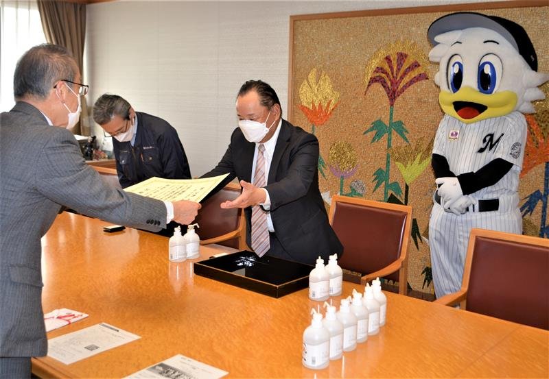 吉村会長に感謝状を手渡す松戸市長。千葉ロッテの「マーくん」も同席した＝船橋市役所
