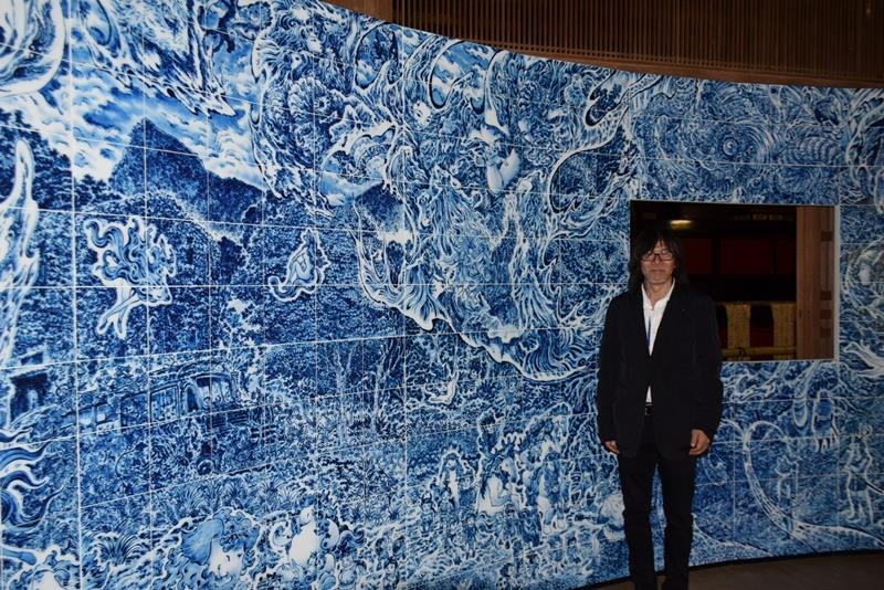 講堂内に展示されている壁画と葉山さん＝匝瑳市
