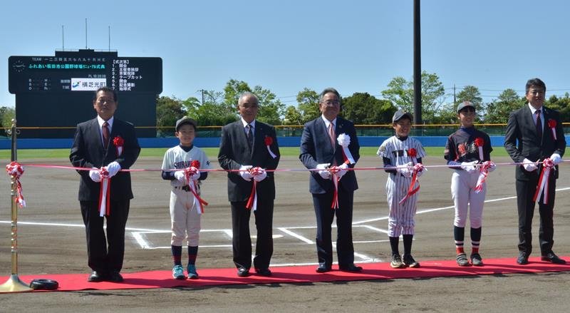ふれあい坂田池公園野球場の改修記念式典でテープカットする佐藤町長（左から４人目）ら＝横芝光町
