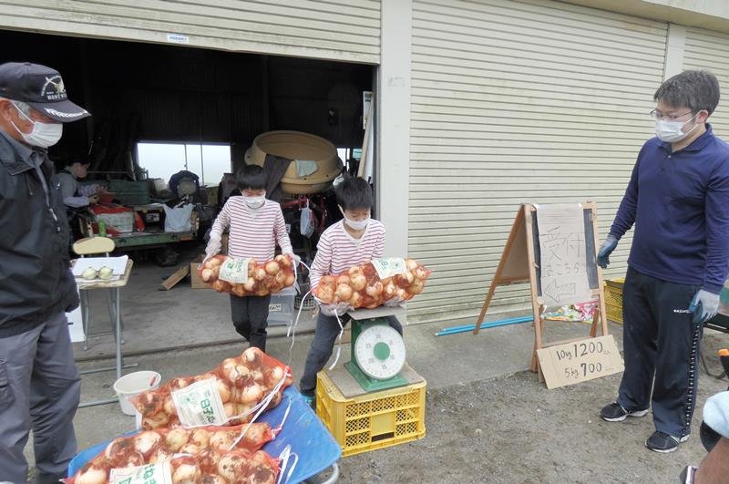 袋詰めしたタマネギの重さを量る子どもたち＝５月１日、白子町
