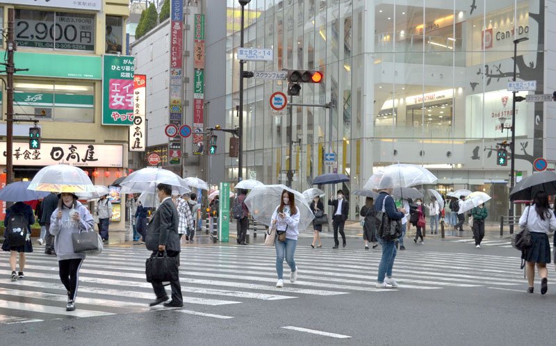 気象庁が関東甲信の梅雨入りを発表した６日。雨の中、傘を差して歩く人たち＝午後５時半ごろ、千葉市中央区