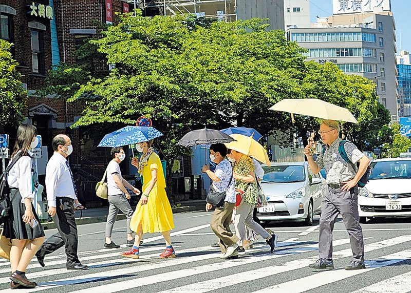 千葉市中央区の交差点では日傘を差す通行人の姿が目立った＝３０日午後２時ごろ