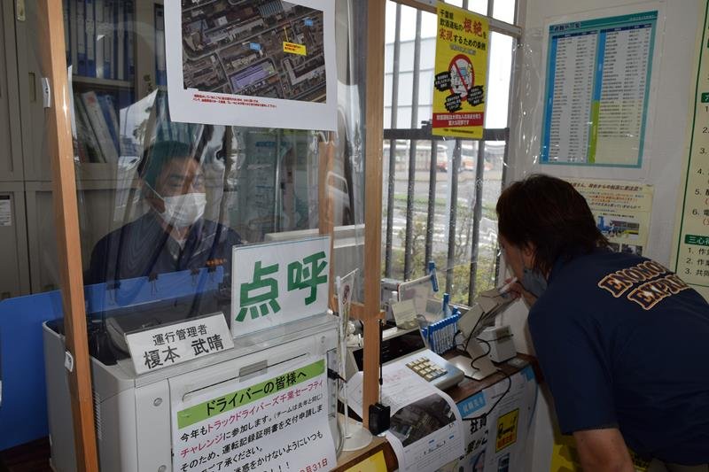 乗務が終わったドライバー（右）のアルコール検知を行う榎本社長＝木更津市